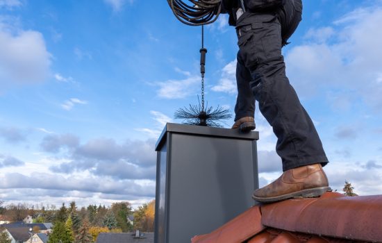 Chimney,Sweep,Cleaning,A,Chimney,Standing,On,The,House,Roof,